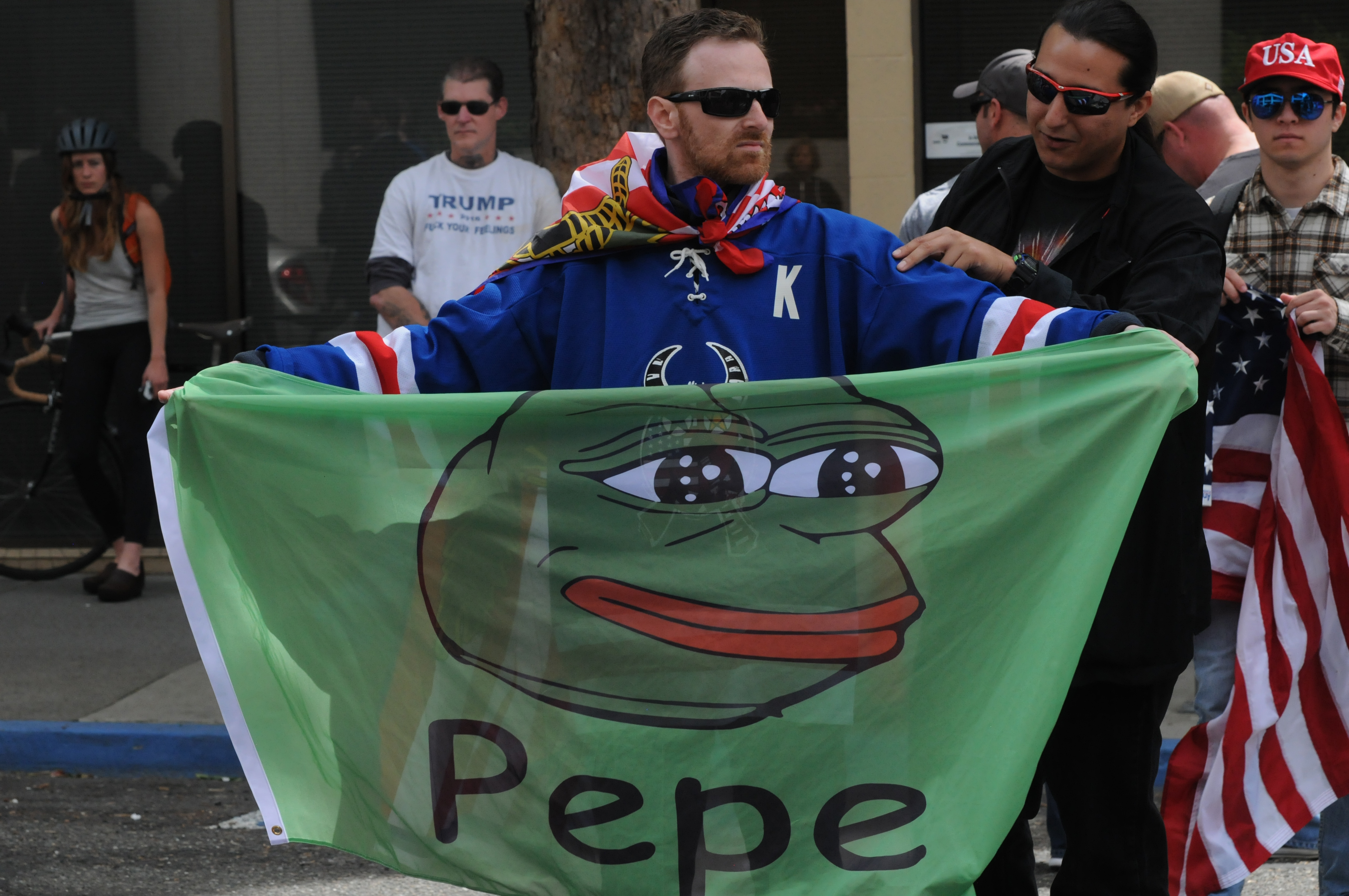 Homem segurando imagem do Pepe the Frog