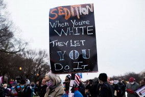 Nadine Seiler holds a sign denouncing last year’s events at a vigil outside the U.S. Capitol 