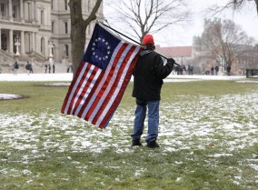 Person holding early American flag with 13 stars