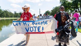 People carry banner that reads: Let my people vote!