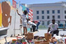 Students work on mural wall