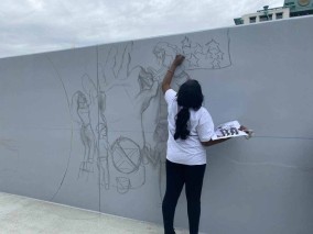 Students work on mural wall