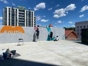 Students work on mural wall