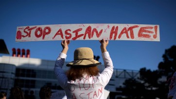 Person holds sign that reads "Stop Asian Hate"