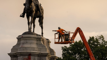 a confederate statue and construction worker