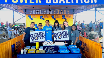 Activists for Geaux Vote stand in a booth