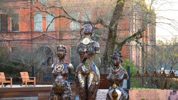 Three metal sculptures symbolizing women used in medical procedures.