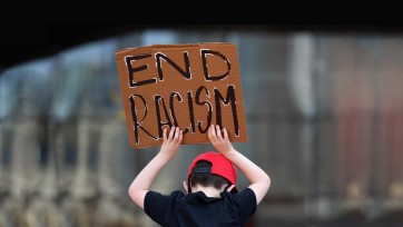 Child holds sign that reads End Racism