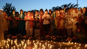 People hold candles at prayer vigil