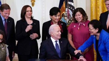 President Joe Biden and Vice President Kamala Harris surrounded by members of Congress