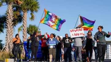 Marchers wave LGTBQ flags and signs
