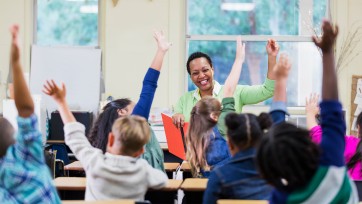 teacher and students raising hands