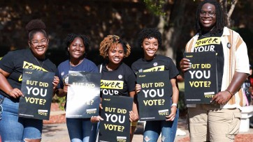 College students hold placards with message encouraging people to vote