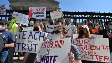 Community members hold signs calling for the teaching of inclusive education in Georgia schools