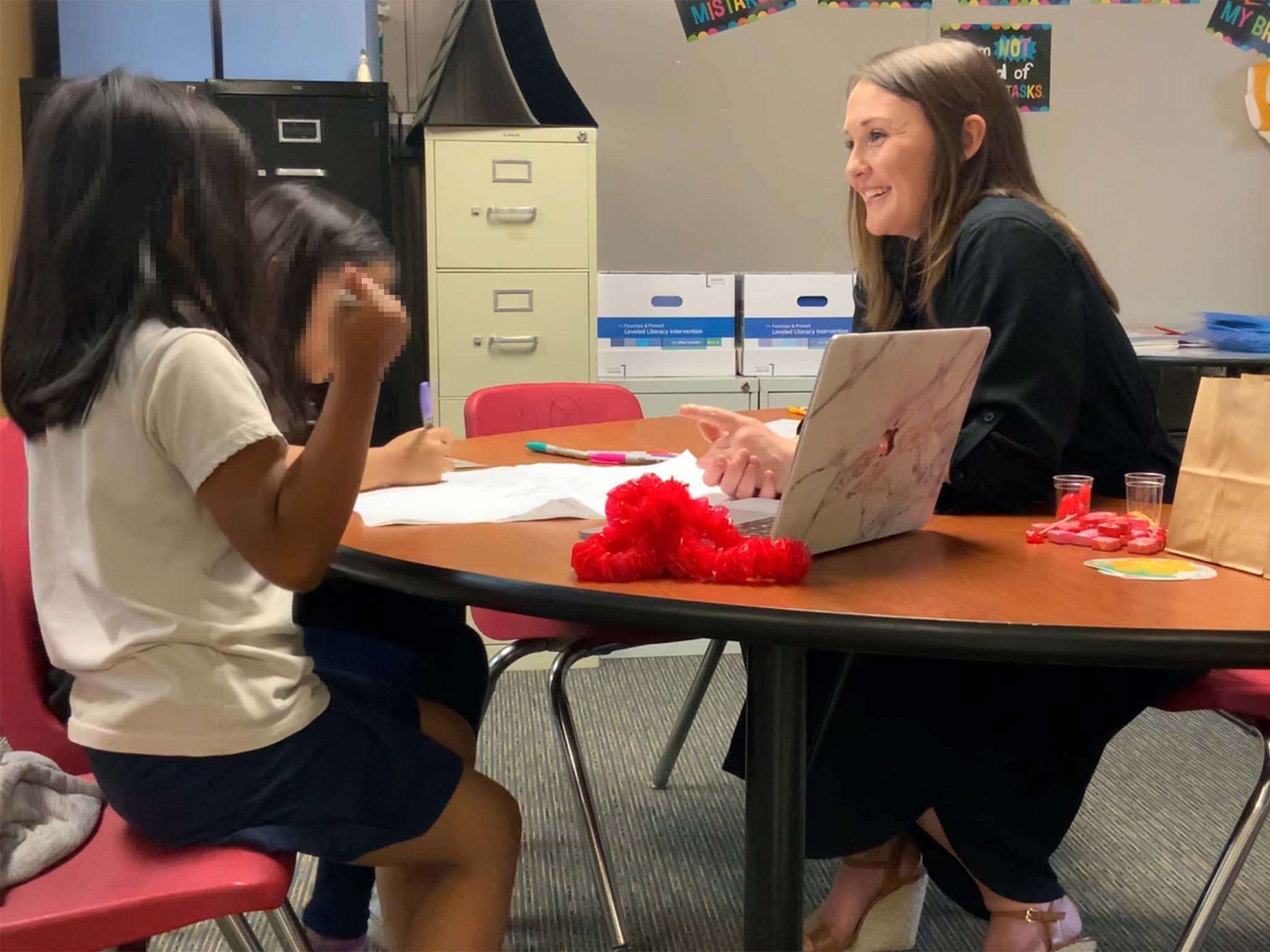 Teacher in class with children (obscured)