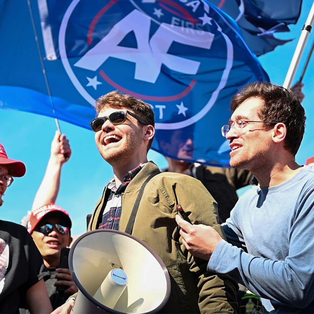 Nick Fuentes with America First flag in background