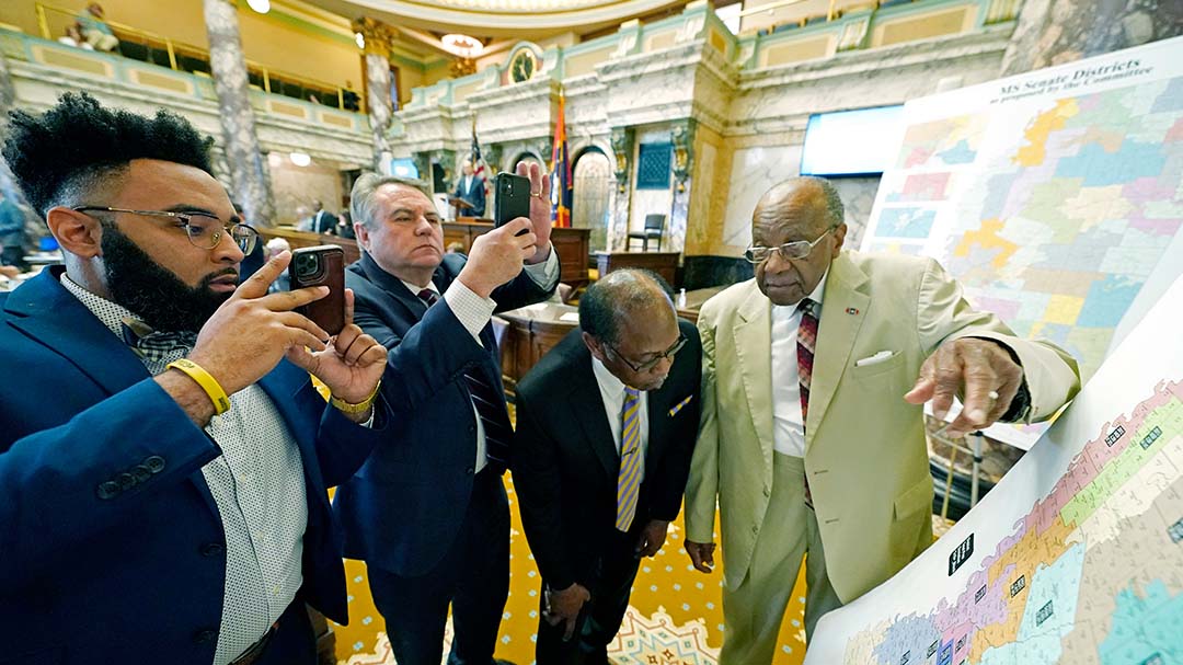 People gather with cellphones to take photos of map on display 