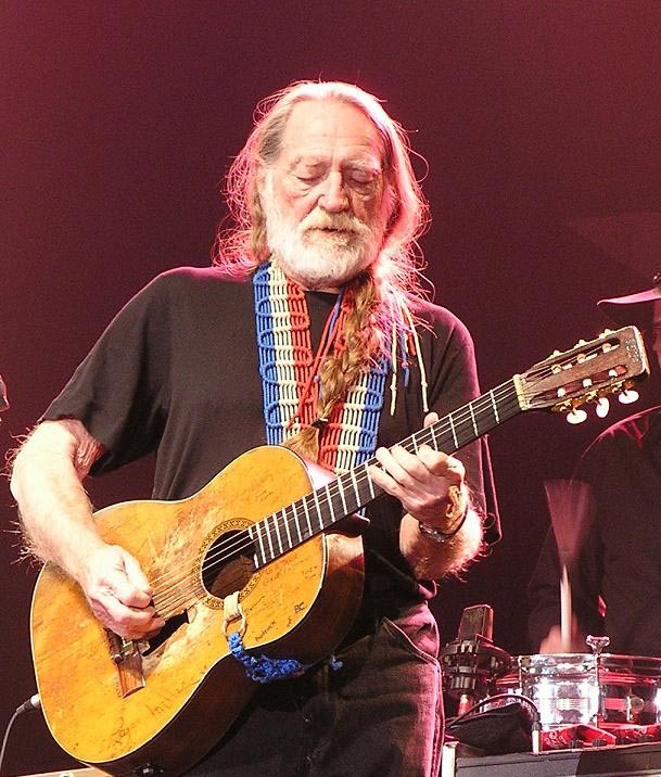 Willie Nelson playing guitar.
