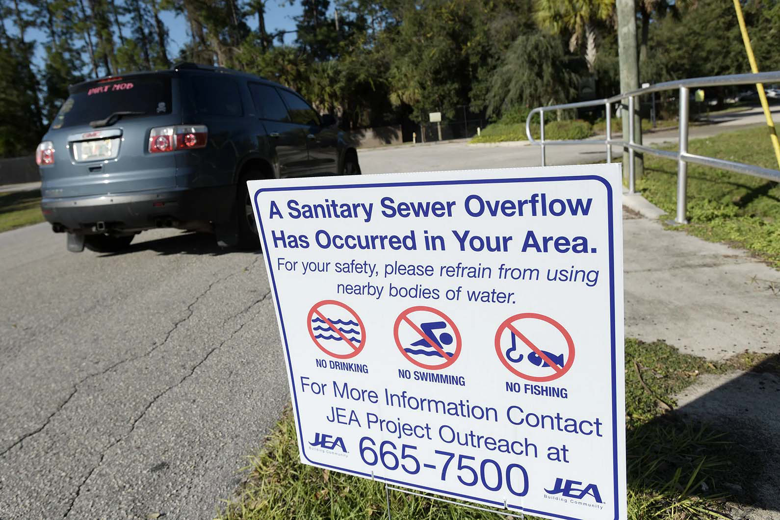 a sign on a road reads "A Sanitary Sewer Overflow has Occurred in Your Area"