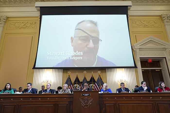 Video showing Elmer Stewart Rhodes plays on screen above congressional panel hearing