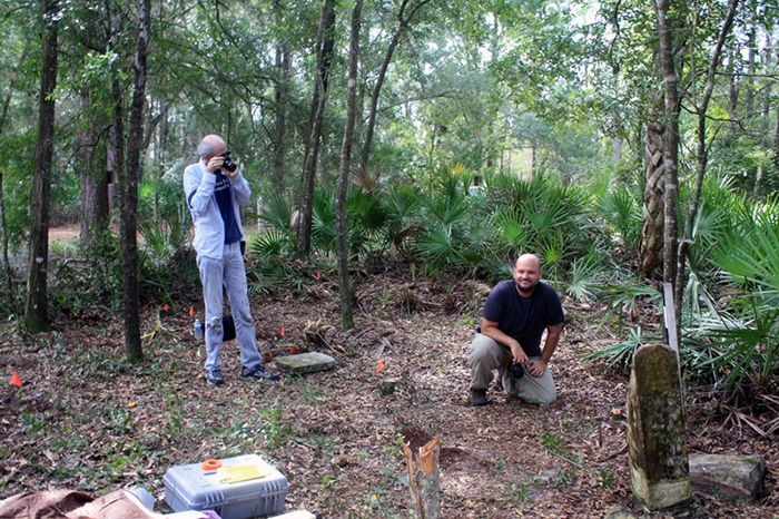 Two people in field amid cemetery markers