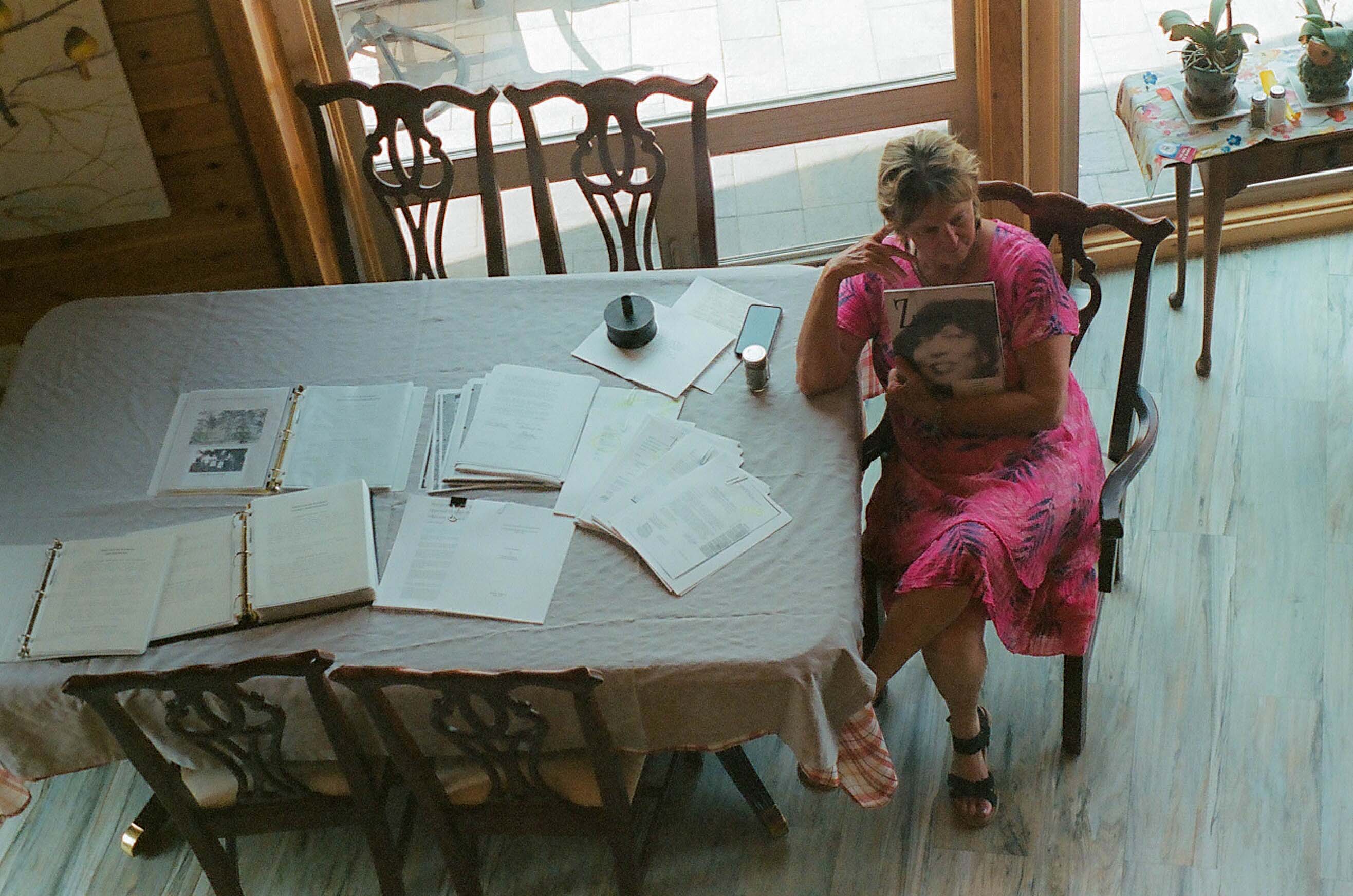  Bea Leach Hatler holds papers while seated at head of table