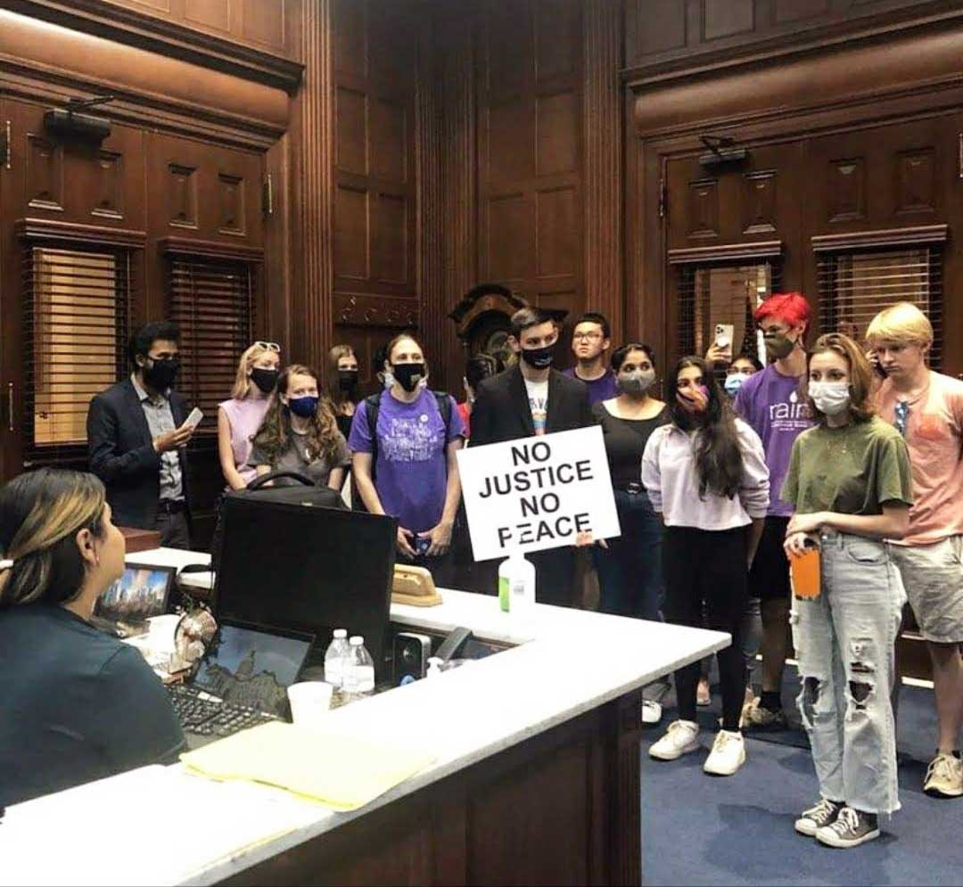 Students inside Georgia Governor office with sign "No Justice No Peace"
