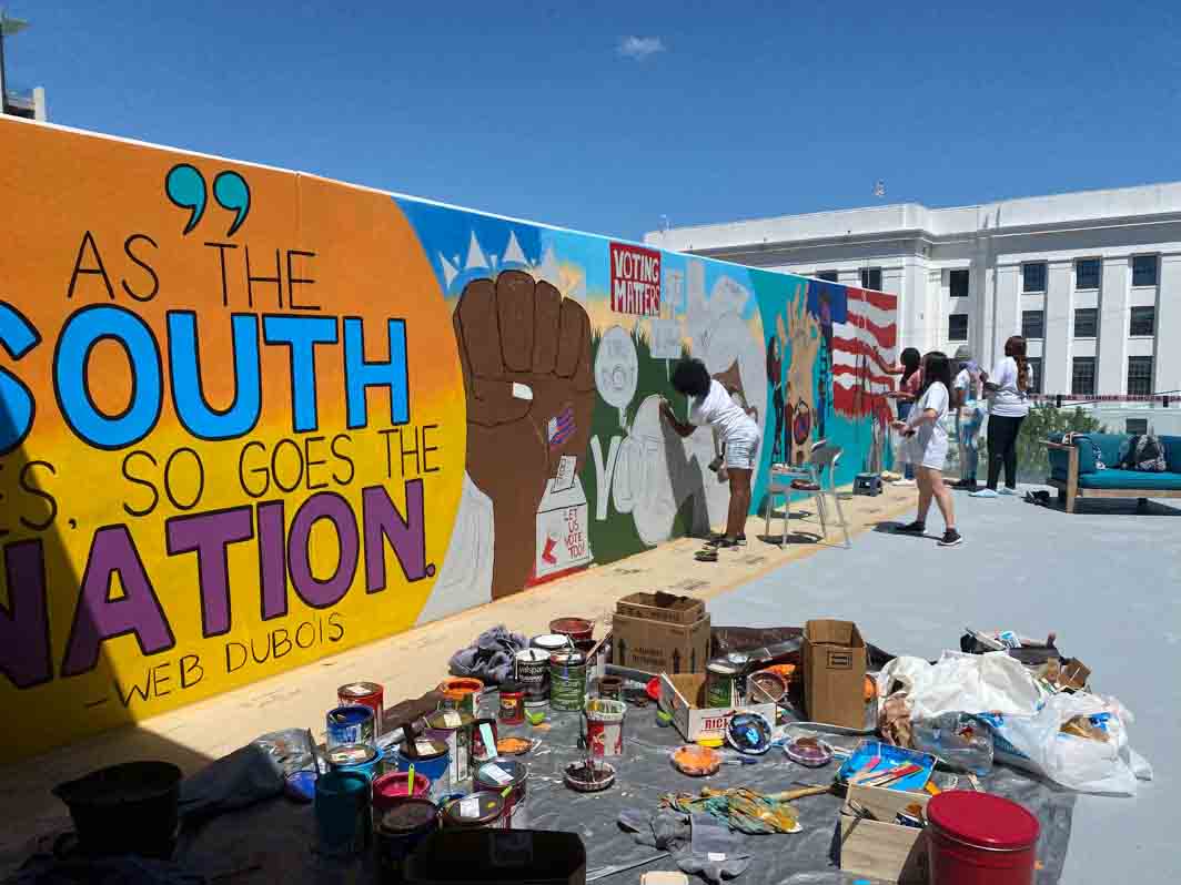 Students work on mural wall