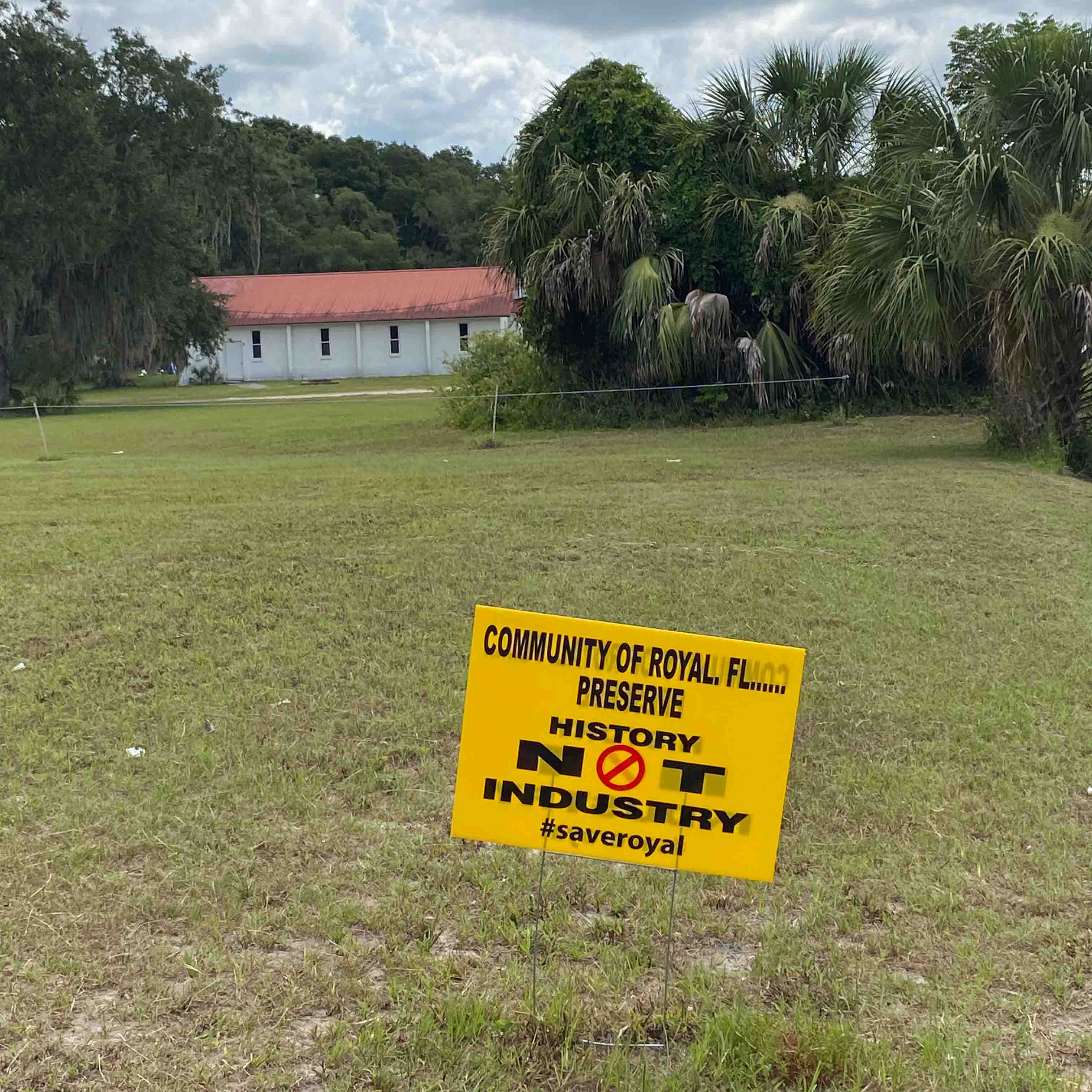 Yellow sign on lawn that reads: "Community of Royal, Florida. Preserve history not industry. #saveroyal."