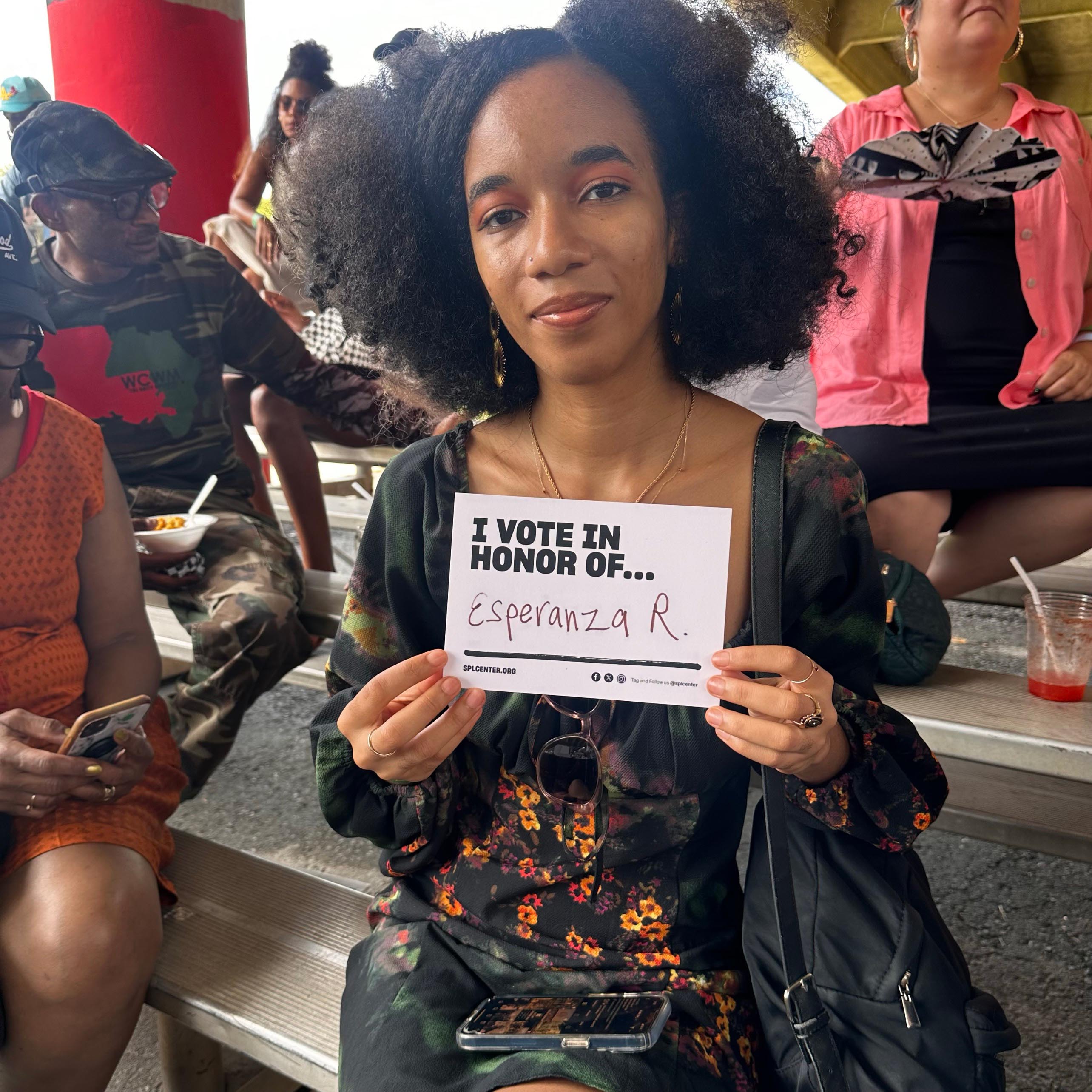 Person holds card with name of someone unable to vote.