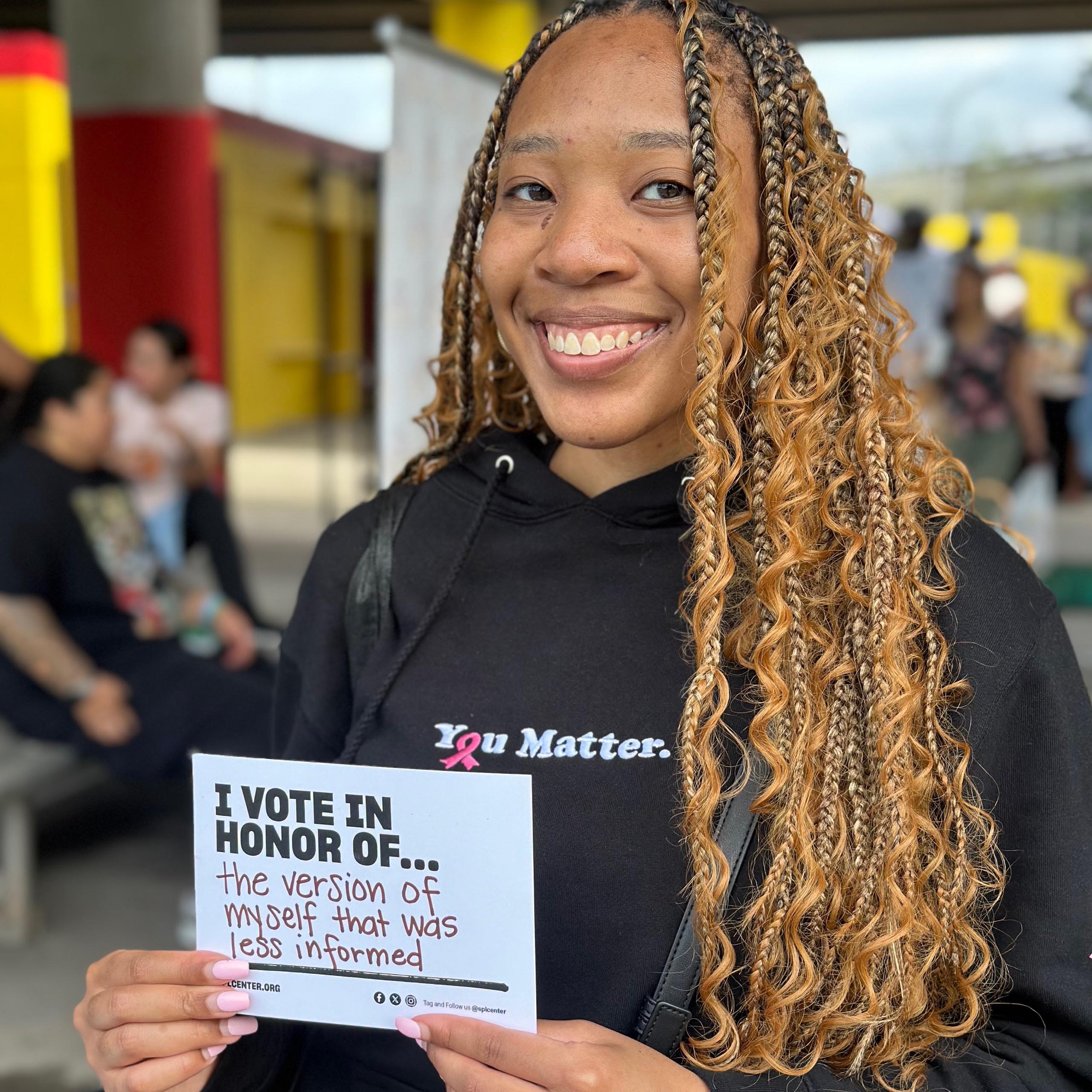 Person holds card with name of someone unable to vote.