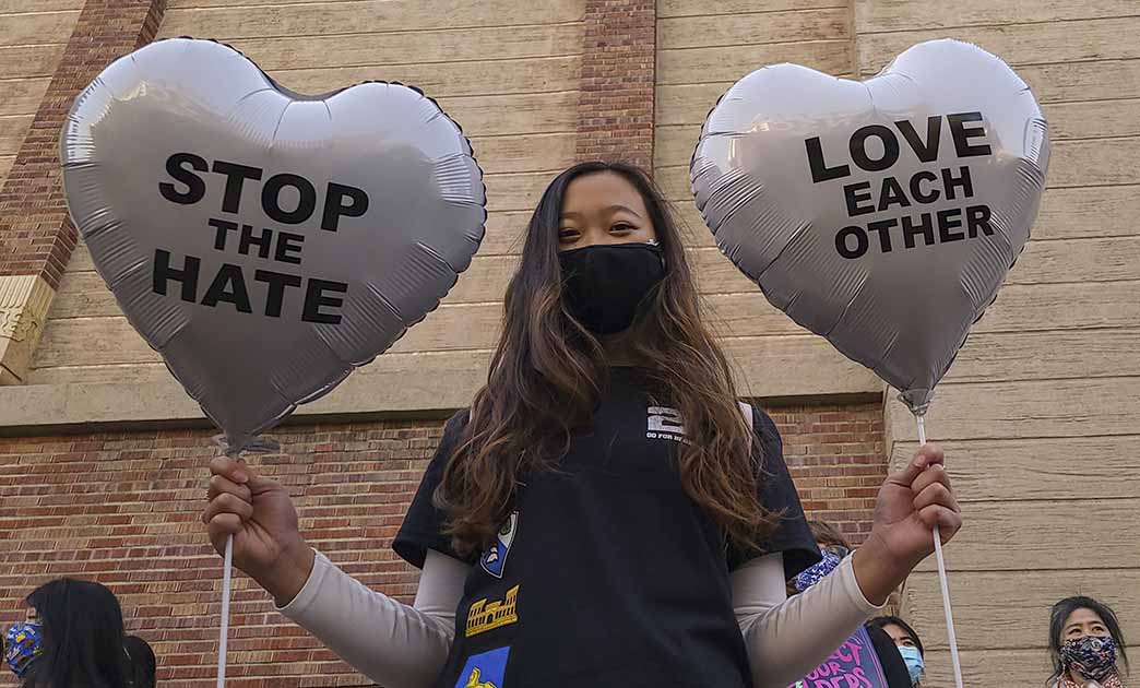 Student holds a pair of heart balloons