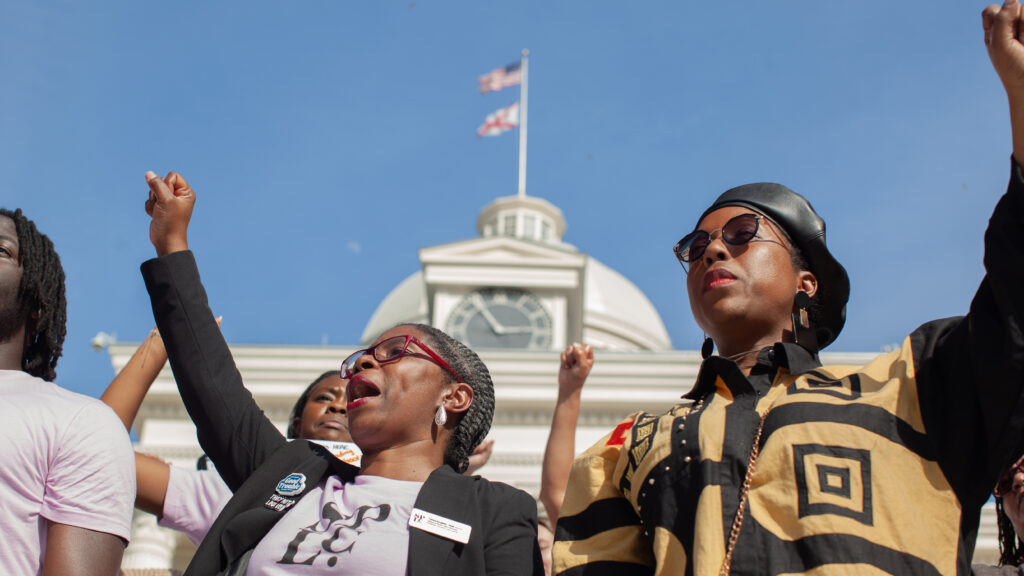 Two women raise their fists during a protest outside the U.S. Capitol.