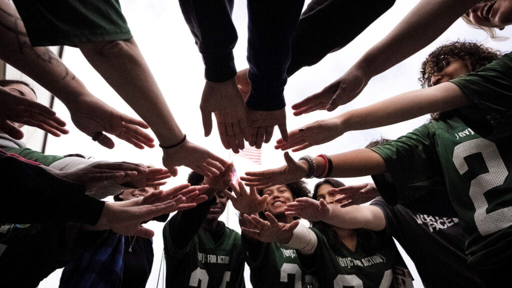 Group pointing hands into center of huddle.