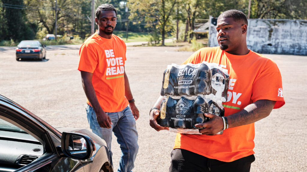 People load water into vehicle.