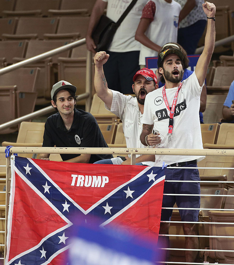 People raise arms before a flag is draped over railing.