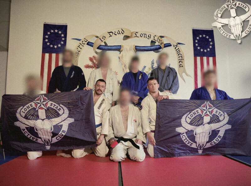 men in a gym, wearing jiu-jitsu gis, surrounded by white nationalist imagery.