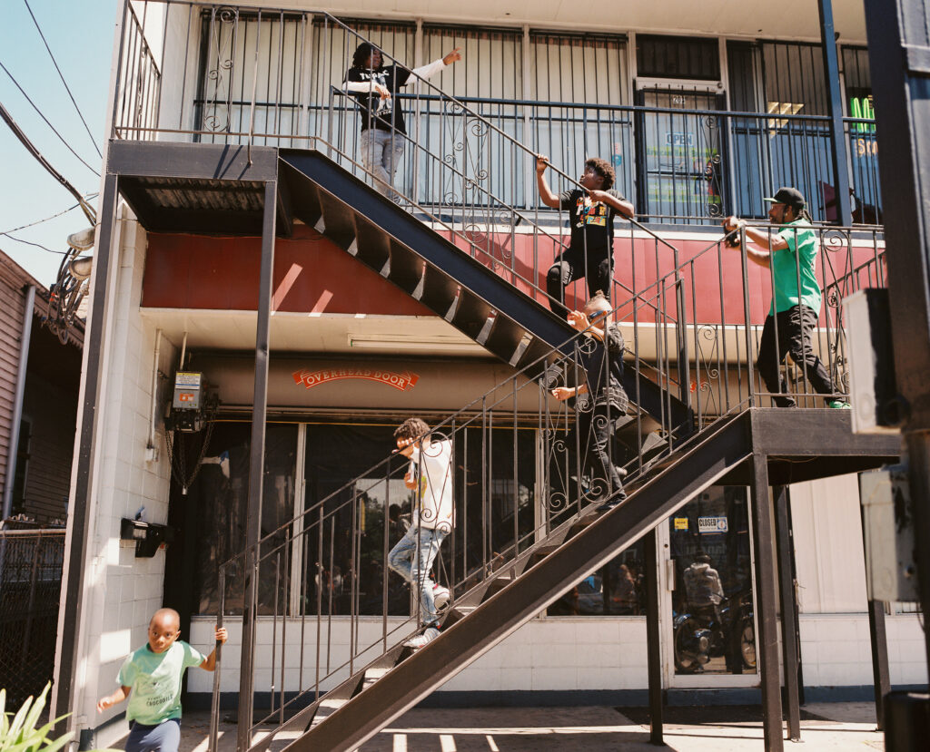 People walking up and stairs outside a two-story building.