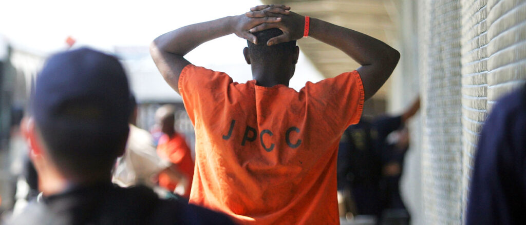 A person holds his hands on back of his head.