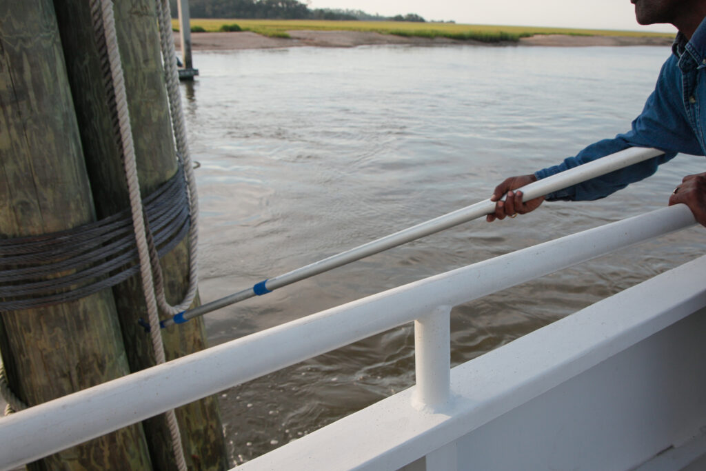 Person pushes off dock with a pole.