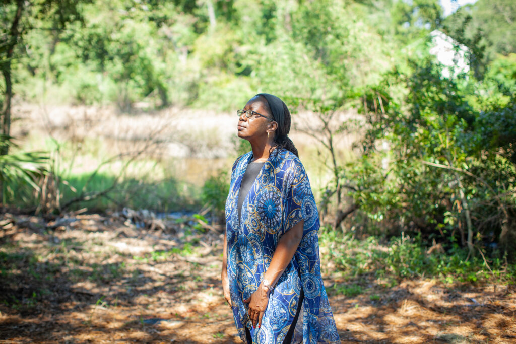 Person in exterior setting under shaded trees.