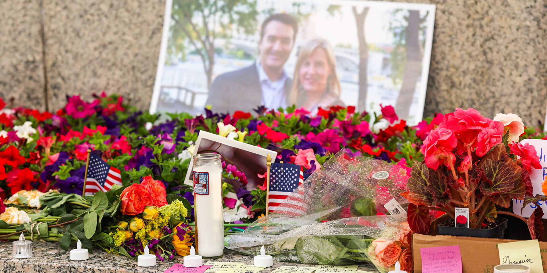 A memorial with flowers, a candle, and a photograph of a couple.