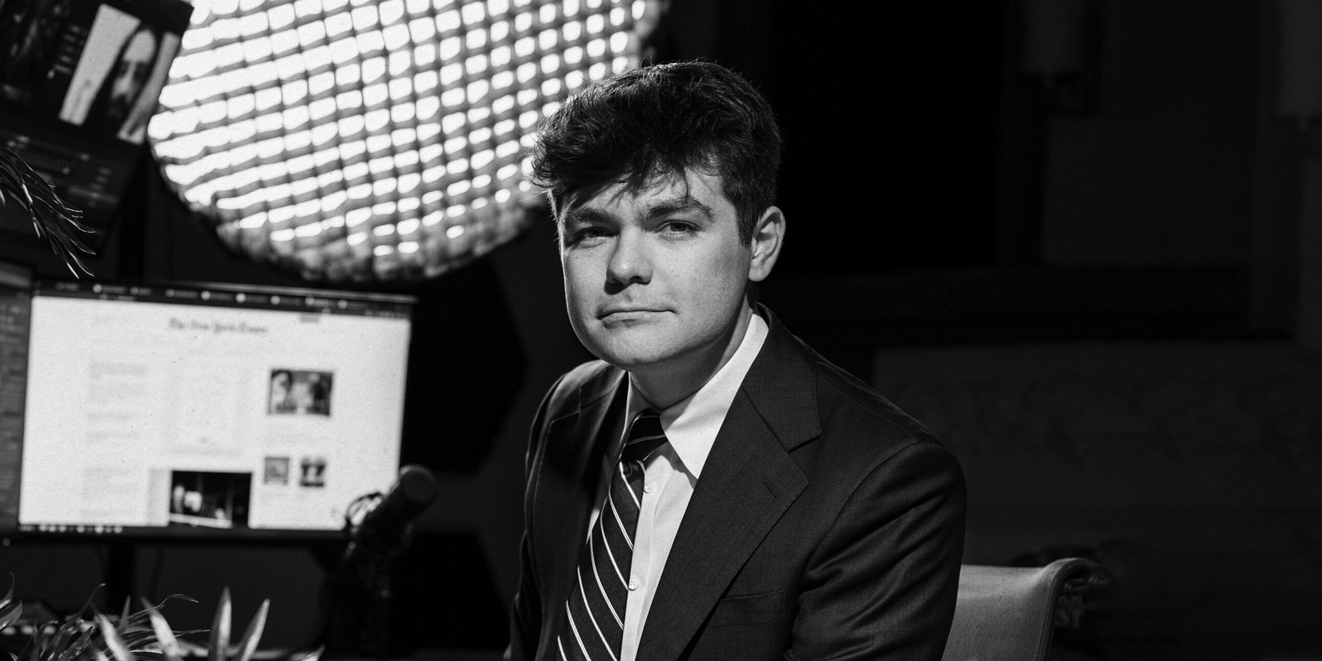 Portrait of figure in front of a computer screen.