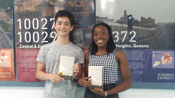 Two students holding copies of the book 