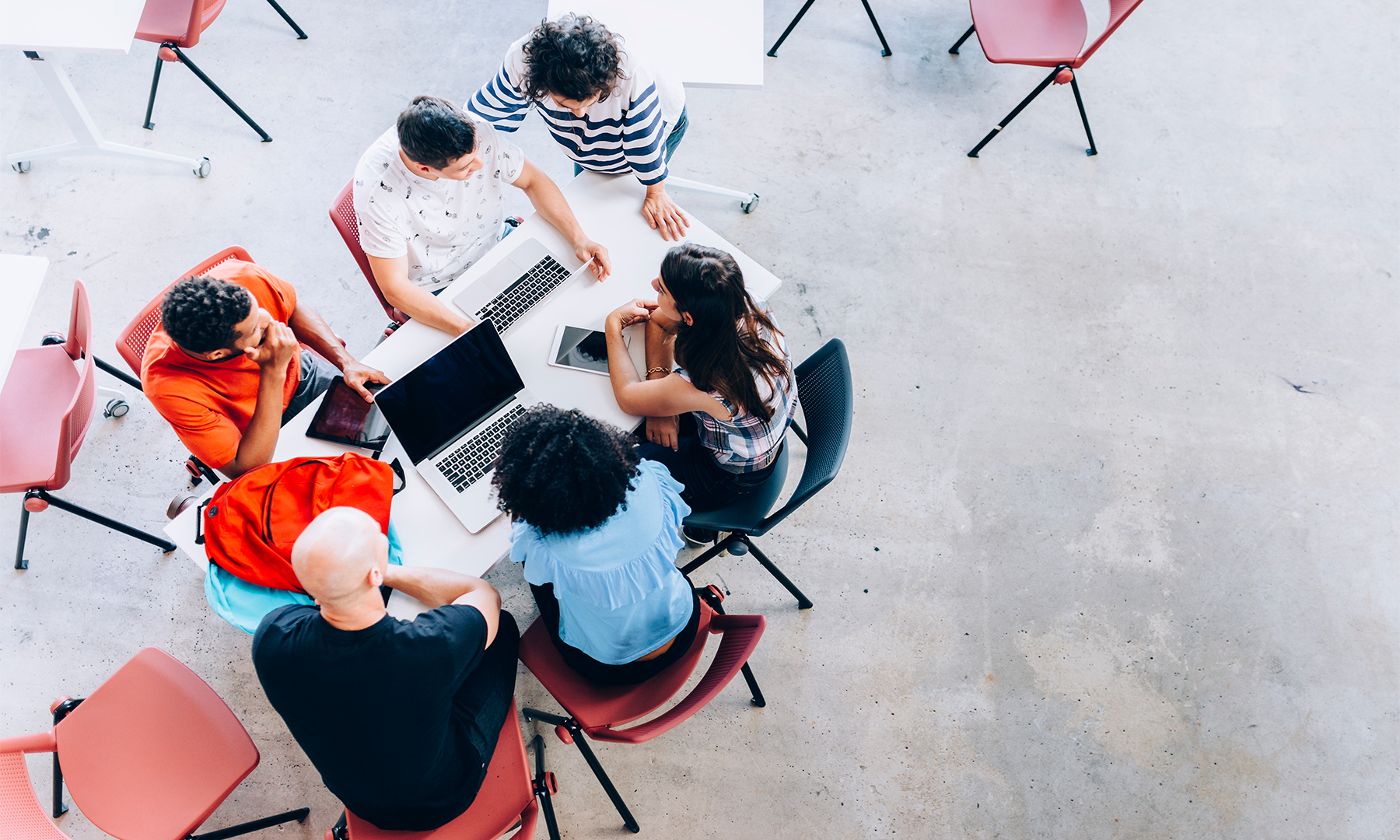 Group of students and teacher sitting around table having a discussion